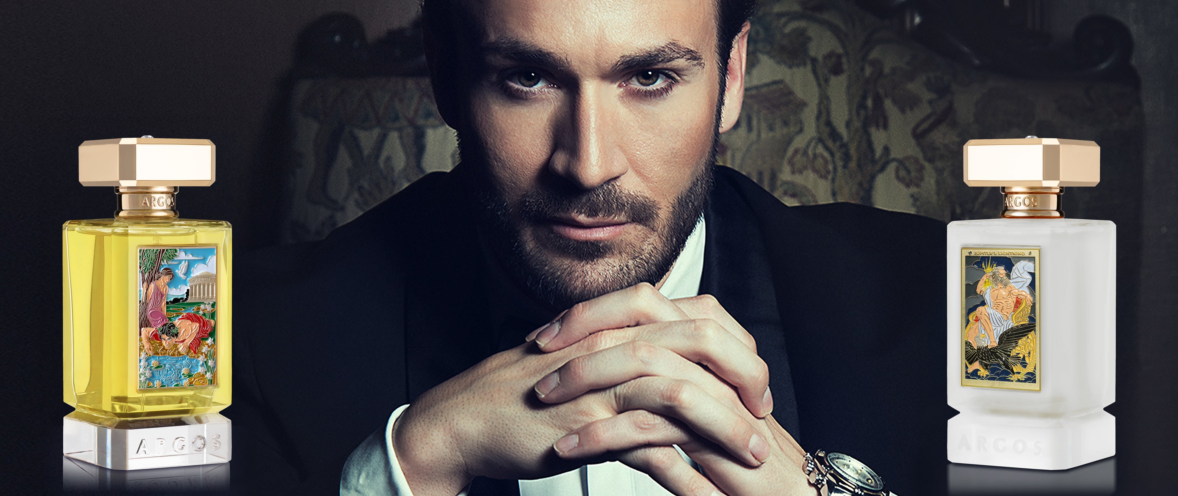 Christian Petrovich in a suit with two Argos new release perfume bottles in the foreground