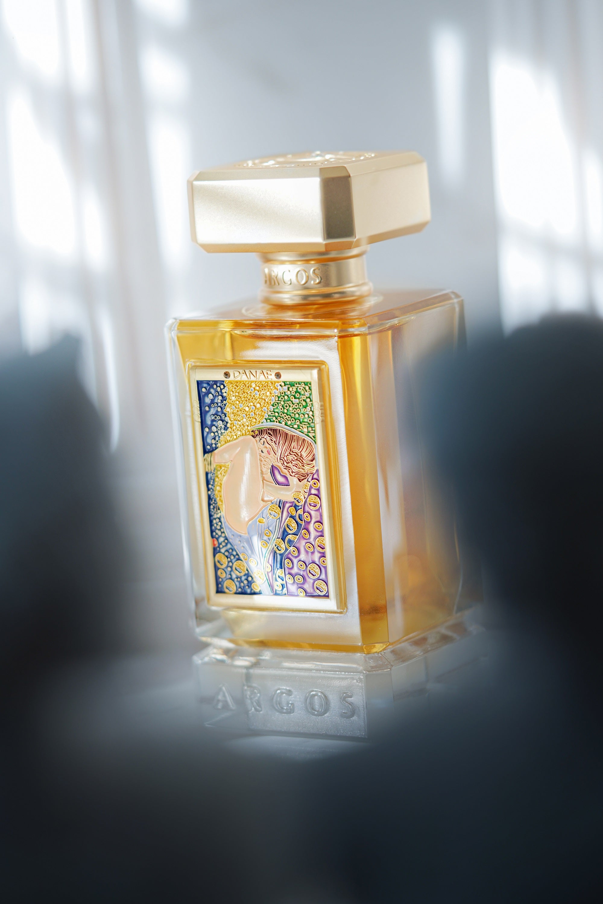 Argos DANAE Perfume 100ml Bottle Placed Little Long Distance with Right Side Direction and the Front Portion Convered with Roman Sculptures