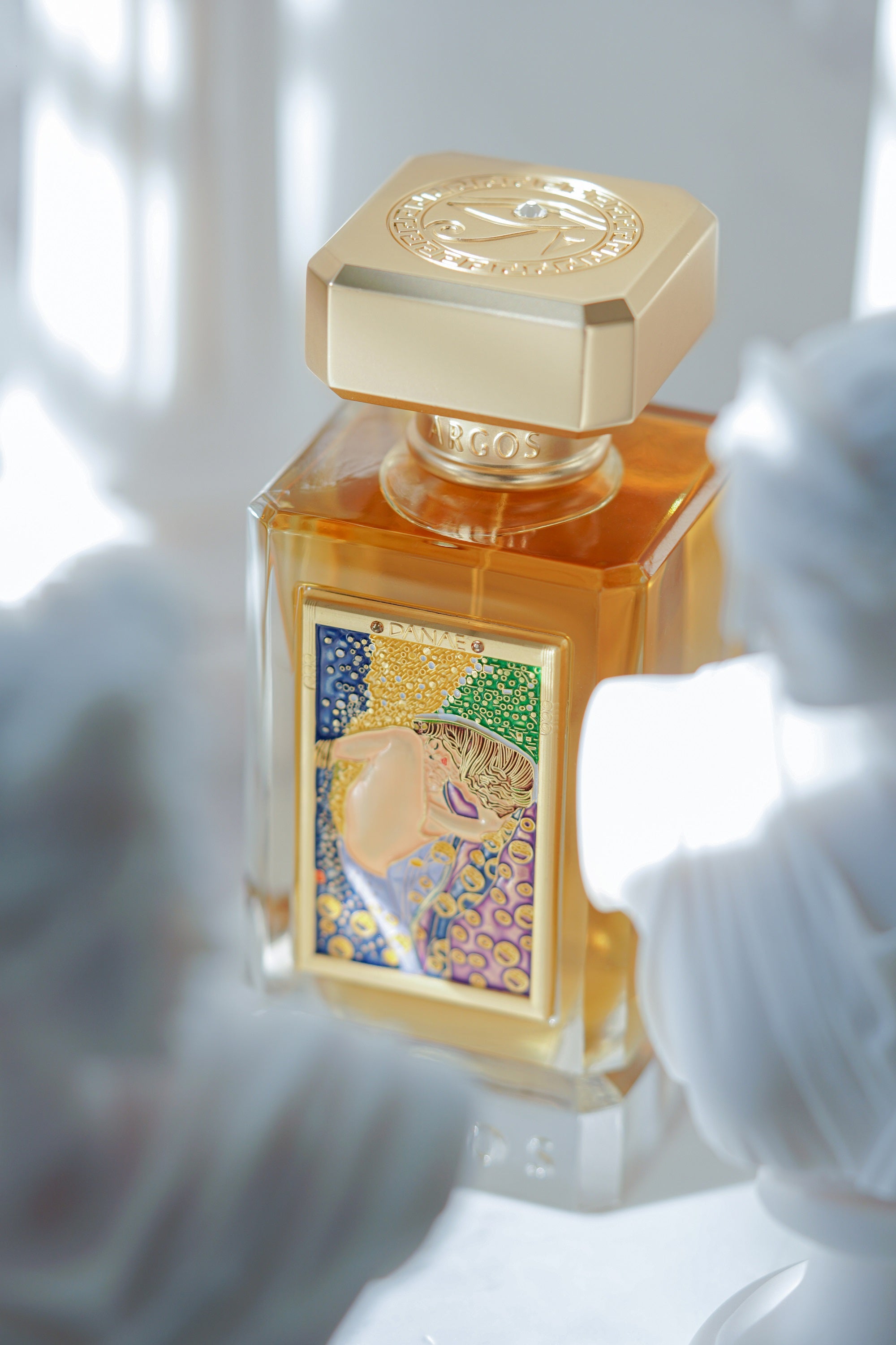 Argos DANAE Perfume 100ml Bottle Placed in Short Distance with Little Right Side Direction and the Front Portion Convered with Roman Sculptures